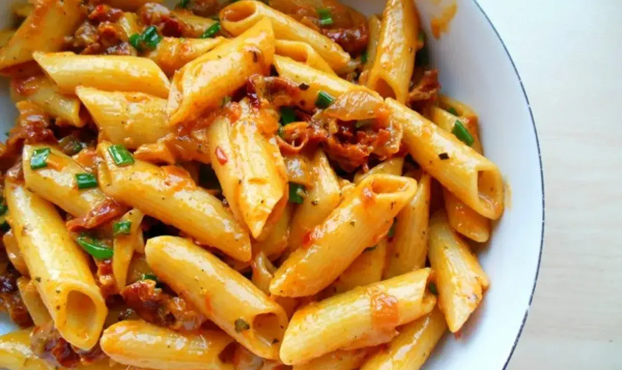 Penne w kremowym sosie z suszonymi pomidorami i szczypiorkiem. Pyszne danie, które zachwyci każdego smakosza makaronu.