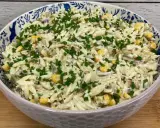 Pyszna sałatka z tuńczykiem i makaronem orzo, z kukurydzą i szczypiorkiem, w ozdobnej misce.