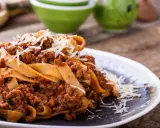Pappardelle z bogatym sosem bolognese, posypane parmezanem. Pyszne mięso na spaghetti wprost z Włoch.