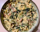 Pyszny makaron farfalle w kremowym sosie ze szpinakiem i kawałkami boczku.