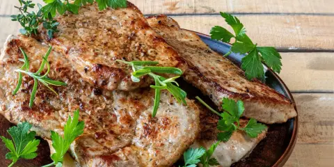 Soczysty schab z airfryer, idealnie przypieczony, podany z gałązkami rozmarynu i natki pietruszki. Pyszne i zdrowe danie.