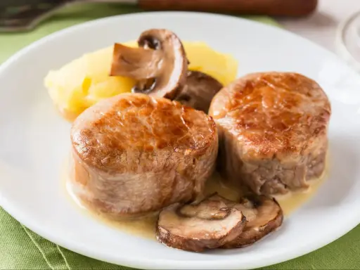 Dwa medaliony z polędwicy wieprzowej z pieczarkami i puree ziemniaczanym. Idealny polędwica wieprzowa przepis na obiad.