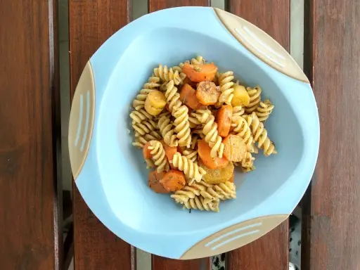 Szybki obiad dla niemowlaka: makaron fusilli z marchewką i ziemniakami, doprawiony ziołami.
