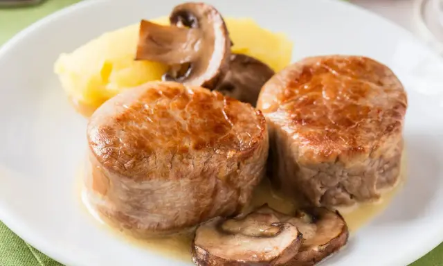 Dwa medaliony z polędwicy wieprzowej z pieczarkami i puree ziemniaczanym. Idealny polędwica wieprzowa przepis na obiad.
