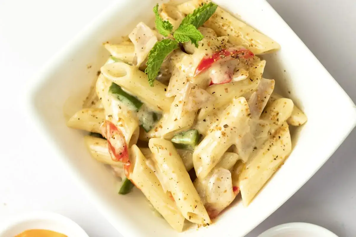 Penne z kurczakiem w kremowym sosie, z papryką i natką pietruszki. Pyszne danie, które z pewnością zadowoli każdego smakosza.